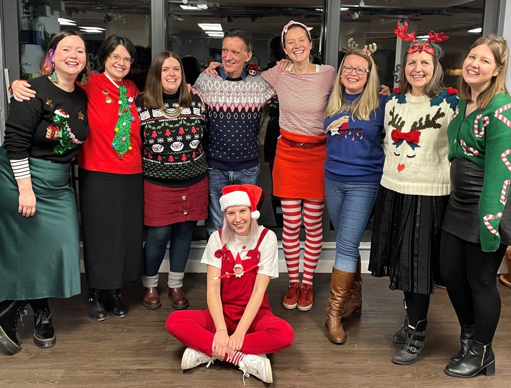 Picture of some Committee and Events Team members (standing) from left to right - Helen Jones, Janice Crossfield, Kat Slater, Mike Hanson, Katell Sevellec, Kate Lo, Laurence Bisot and Chloe Stout with Dot Roberts sat cross-legged on the floor